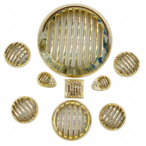 Complete 10-piece set of vintage gold polished brass motorcycle grille covers including headlight, indicator, and accent grilles, arranged on a clean white background."