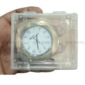 A Royal Enfield branded analog clock in a brass-colored housing, displayed inside a clear plastic protective case held in a hand.
